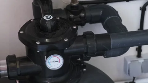 Close-up of a pool filtration valve system with connected plastic pipes and a bu Stock Footage 312019040