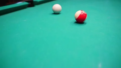 Close-up pool table action with cue ball and striped ball near corner pocket Vidéo 327887025