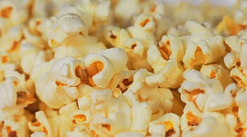 Close-up of popcorn background and a hand picks one piece of popcorn Video stock 65003311