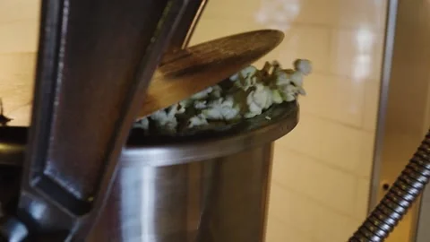 A Close up of popcorn cooking in popcorn machine kettle in movie theater lobby Stock Footage 155450661