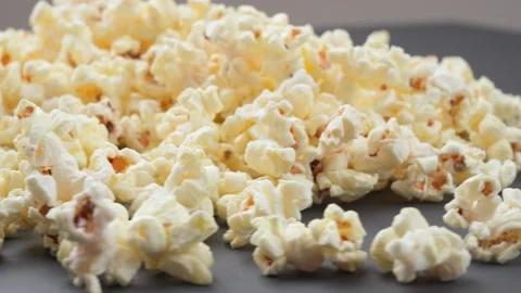 Close-up, popcorn rotates on a gray table Video stock 160558936
