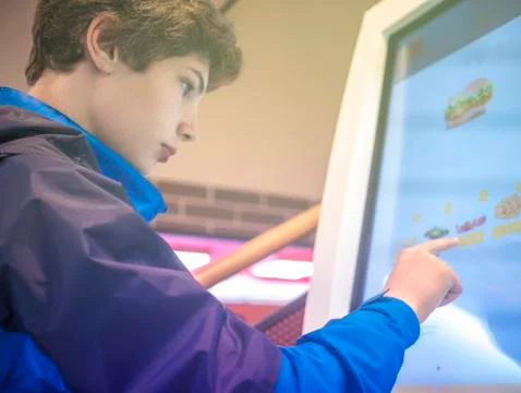Close up poretrait of young man making and order in the cafe using tounh scre Stock Photos