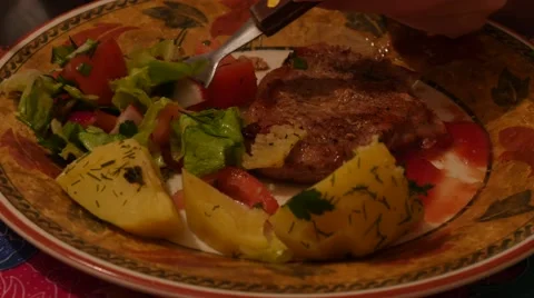 Close up of pork chop with vegetables and potato in the eating process Stock Footage 48229269