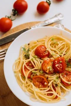 Close up portion of spaghetti pasta with cherry tomatoes sprinkled with spices Fotos Stock