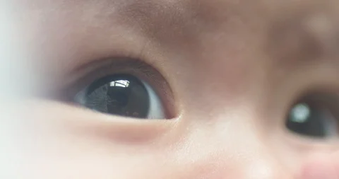 Close up portrait of an Asian childs face as she uses her hands and Stock Footage