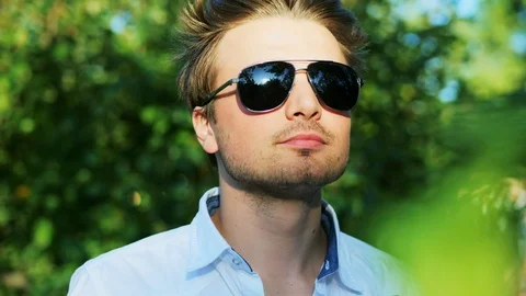 Close-up portrait of attractive man drinks a beer in the park Stock Footage 114138251