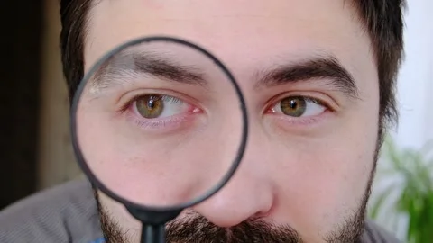 Close up portrait of attractive man looking through magnifying glass at camera Stock Footage 231742611