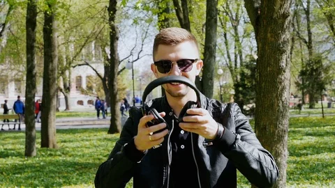 Close-up portrait of attractive man puts on headphones and listening to music Stock Footage 107988424