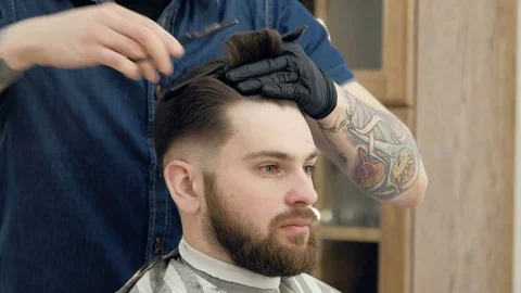 Close-up portrait of attractive young man getting trendy haircut. Male Stock Footage 73534459