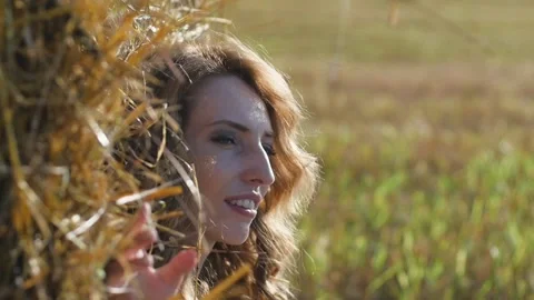 Close-up portrait of attractive young redhead woman sitting near hay Stock-Footage 152497064