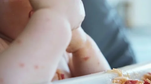 Close-up portrait of baby's hands eating spaghetti dinner and making a mess Stock Footage 196126953