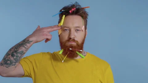 Close-up portrait of bearded man with garbage on him doing gun gesture.  Stock Footage 147178239