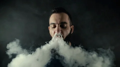 Close-up portrait of a bearded man sends one big steam circle right to camera Video stock 111525056