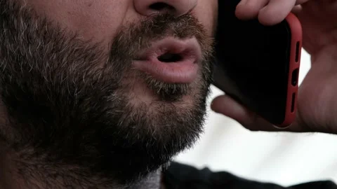 Close up portrait of bearded man talking on smart phone, focus on lips Video stock 137263801