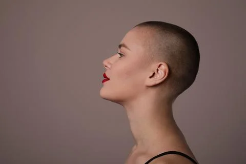 Close-up portrait of beautiful bald young woman, posing in the studio. Isolated. Photos