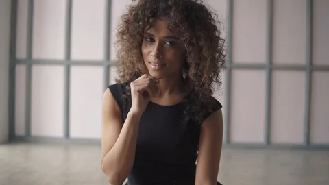 Close-up portrait of a beautiful young hispanic woman in a black dress. curly Stock Footage 88587278