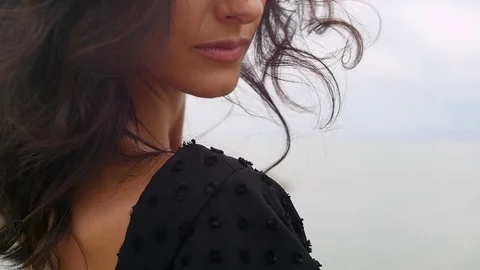 Close up portrait of beautiful young woman running hand through hair blowing in Stock Footage