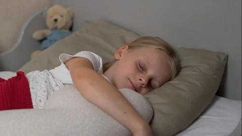 Close-up portrait of a blond child sleeping in his crib snuggling with a cloud Stock Footage 117061173
