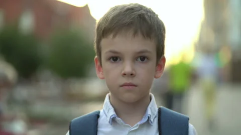 Close-up portrait of a boy with a backpack outdoors looking at the camera Vídeos de archivo 204882710