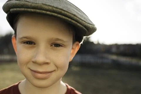Close up portrait of a boy with a flat cap on at sunset Stock Photos