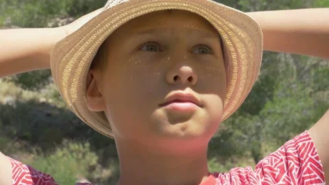 Close up portrait of boy with hat at sunny summer day. Kid raising hands and Stock Footage 133455082