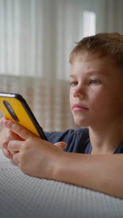 Close-up Portrait of Boy Using Phone, Screen Reflected in Eyes. Stock Footage 320358532