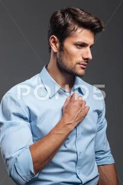 Close up portrait of a casual man buttoning his shirt Stock Photos