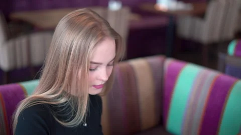 Close up portrait of charming blonde with long hair reading menu in cafe. Stock Footage 145789192