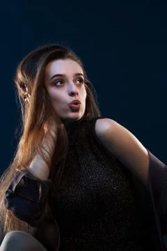 Close-up portrait of charming young thinking woman in black dress looking to  Stock Photos