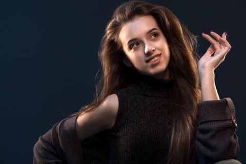 Close-up portrait of charming young thinking woman in black dress looking to  Stock Photos