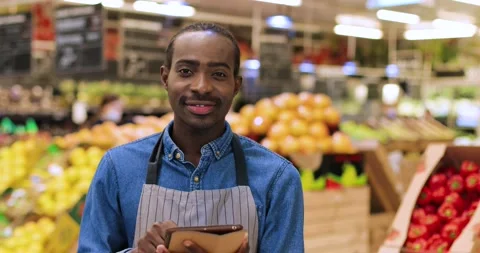 Close up portrait of cheerful guy standing at large supermarket and texting on Stock Footage 143110334