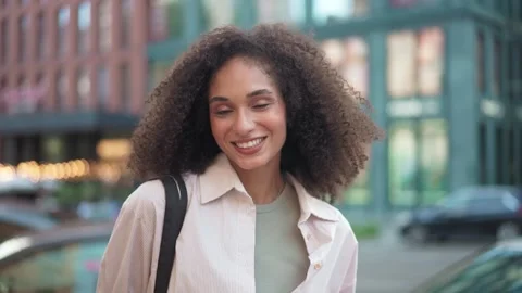 Close-up portrait of a cheerful young beautiful woman with curly hair smiling Stock Footage 311544121