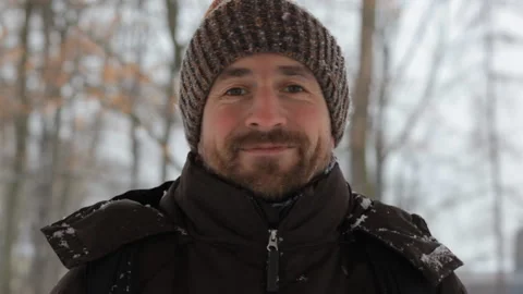 Close up portrait of a cheerful young man smiling at camera in the winter forest Video stock 101037754