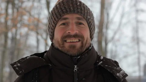 Close up portrait of a cheerful young man smiling at camera in the winter forest Video stock 101037769