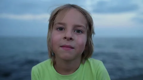 A close-up portrait of a child with a calm expression, gazing directly into the Video stock 285185541