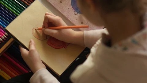 Close portrait of a child draws with colored pencils of a person with a question Stock Footage 127991607