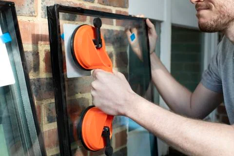 Close Up Of Portrait Of Construction Worker Preparing To Fit Glass Into New W Stock Photos