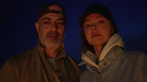 Close-Up Portrait of a Couple Looking on Campfire at Night Stock Footage 306733075