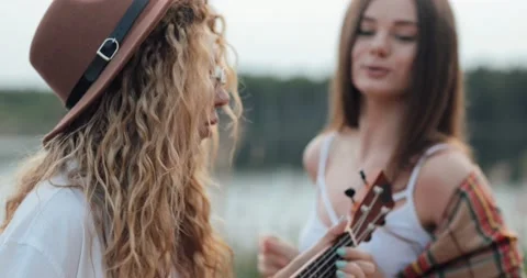 Close Portrait of couple of two lesbian friend girls with ukuleles sing and Stock Footage 132815401