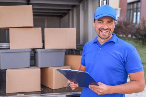 Close-up portrait of a courier or loader in a blue uniform with a baseball cap 스톡 사진