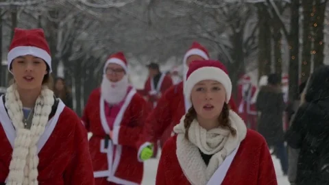 Close up portrait of crowd of Santa Clauses running in street under heavy snow Stock Footage 70646705