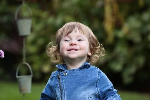 Close up Portrait of Cute 18 Month Old Baby Girl with big blue Eyes and Curly Br Stock Photos