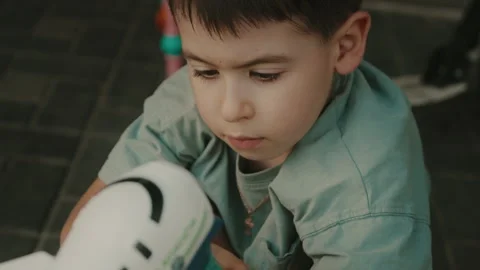 Close-up portrait of a cute boy playing with soap bubbles holding bubble gun it Stock Footage 251667205