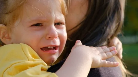 Close-up portrait of a cute crying little girl sitting in her mother arms Stock Footage 116383548