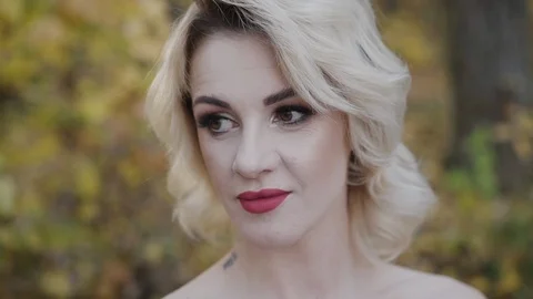 Close portrait of cute lady lightly smiles in autumn park Stock-Footage 124731179