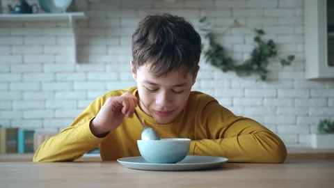 Close-up portrait. Cute school boy enjoying delicious sweet chocolate cereal for Stock Footage 197469979