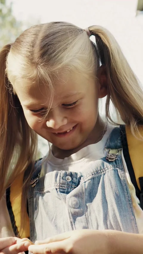 Close up portrait of cute schoolgirl with backpack looking down vertical vide Vídeo Stock 341522845
