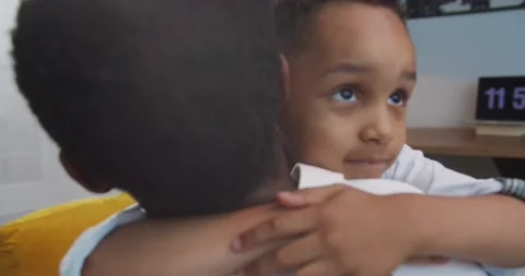 Close up portrait of cute small child hugging his African American father at Stock Footage 137153754