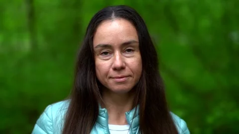Close-up portrait of a dark-haired and long-haired middle-aged woman, she is Vídeos de archivo 131809822