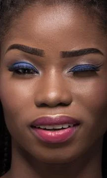 Close up portrait of dark skinned model with one eye closed. Stock Photos